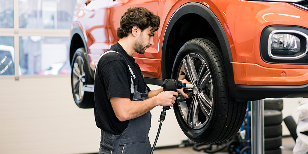 A mechanic changing tires on a car